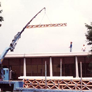 A crane puts building materials in place during a company construction project.