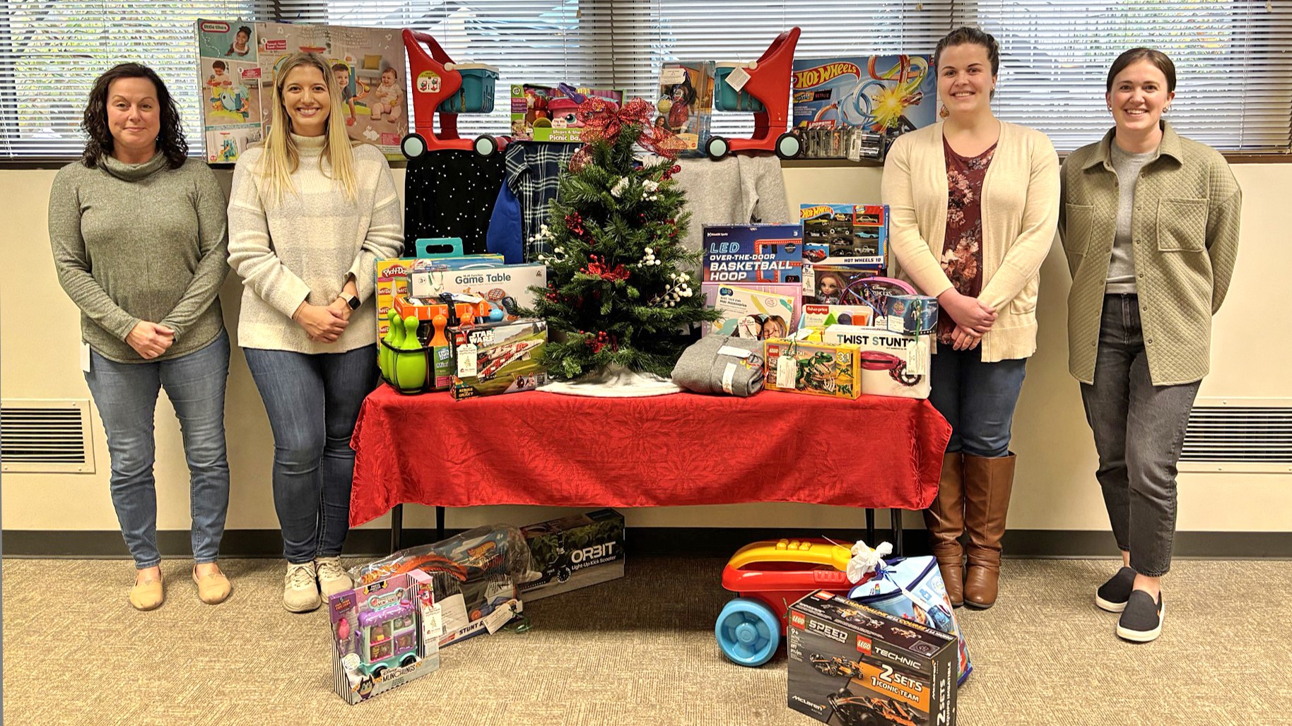 Four Celina Insurance Group employees stand with toys donated for the Mercer County Angel Tree program.