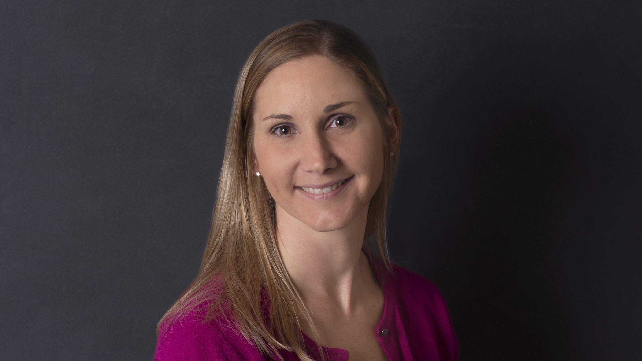 Stephanie Timmerman, Farm Underwriter at Celina Insurance Group, smiles in front of a black background.