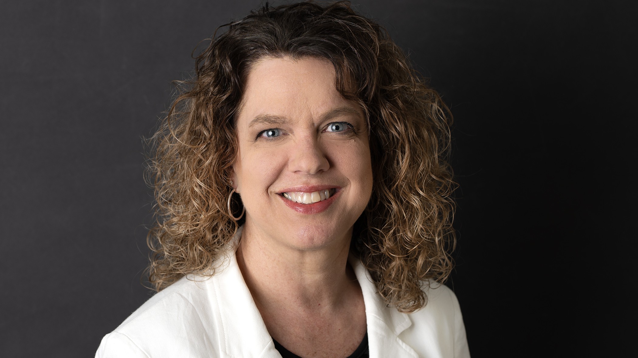 Karla Dieringer, Commercial Underwriting Manager at Celina Insurance Group, smiles in front of a black background.