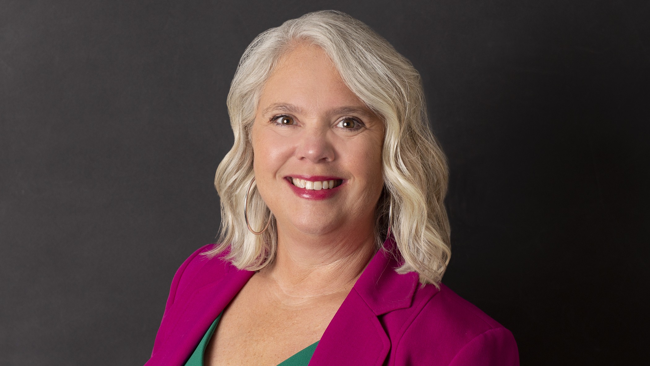Jean LaBarge, Senior Marketing Representative at Celina Insurance Group, smiles in front of a black background