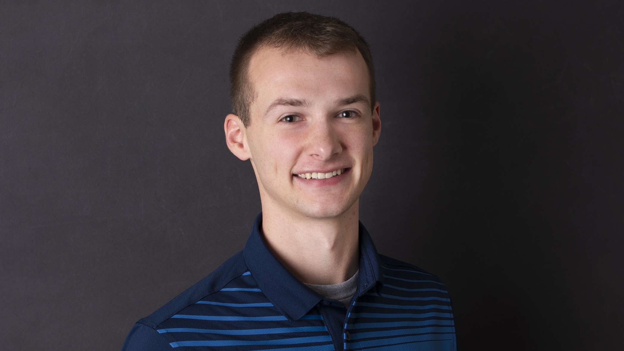 Blake Strickler, Commercial Underwriter at Celina Insurance Group, smiles in front of a black background.