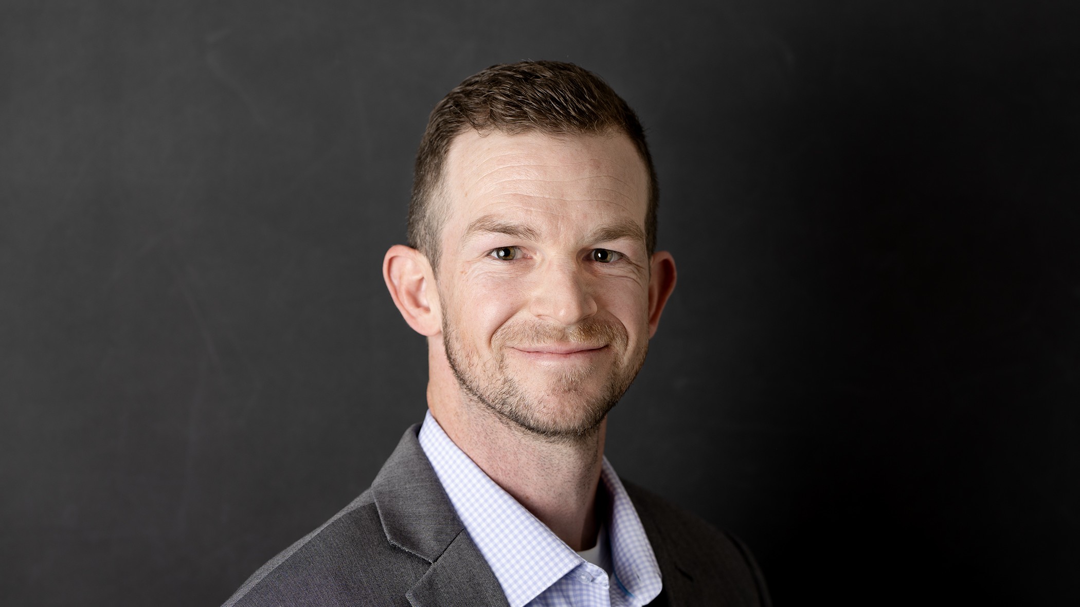 Kurtis Goff, Celina Insurance Group Marketing Representative, smiles in front of a black background.